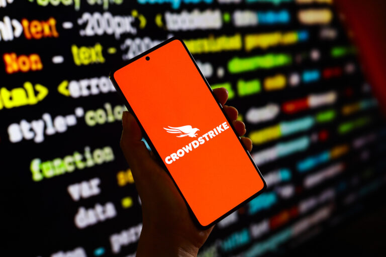 hand holding mobile phone with CrowdStrike logo 733444698